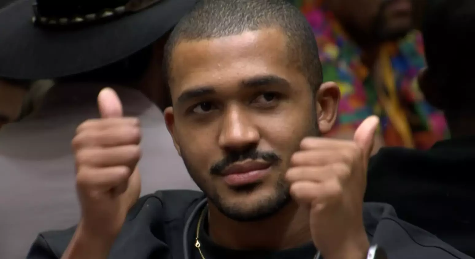 Matheus acena ao ser informado por Tadeu Schmidt de sua eliminação no BBB26 - Foto: Reprodução/Globoplay